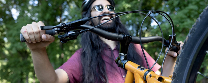 Cyclist smiles while riding a bike equipped with the Whisky Scully Handlebar.