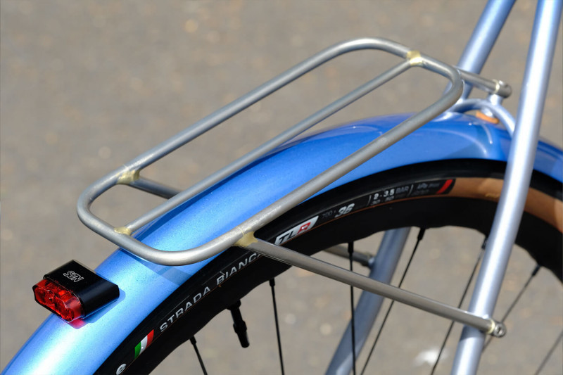 Closeup of the rear fender, rack, and tail light on the Victore Cycles blue randonneur bike.